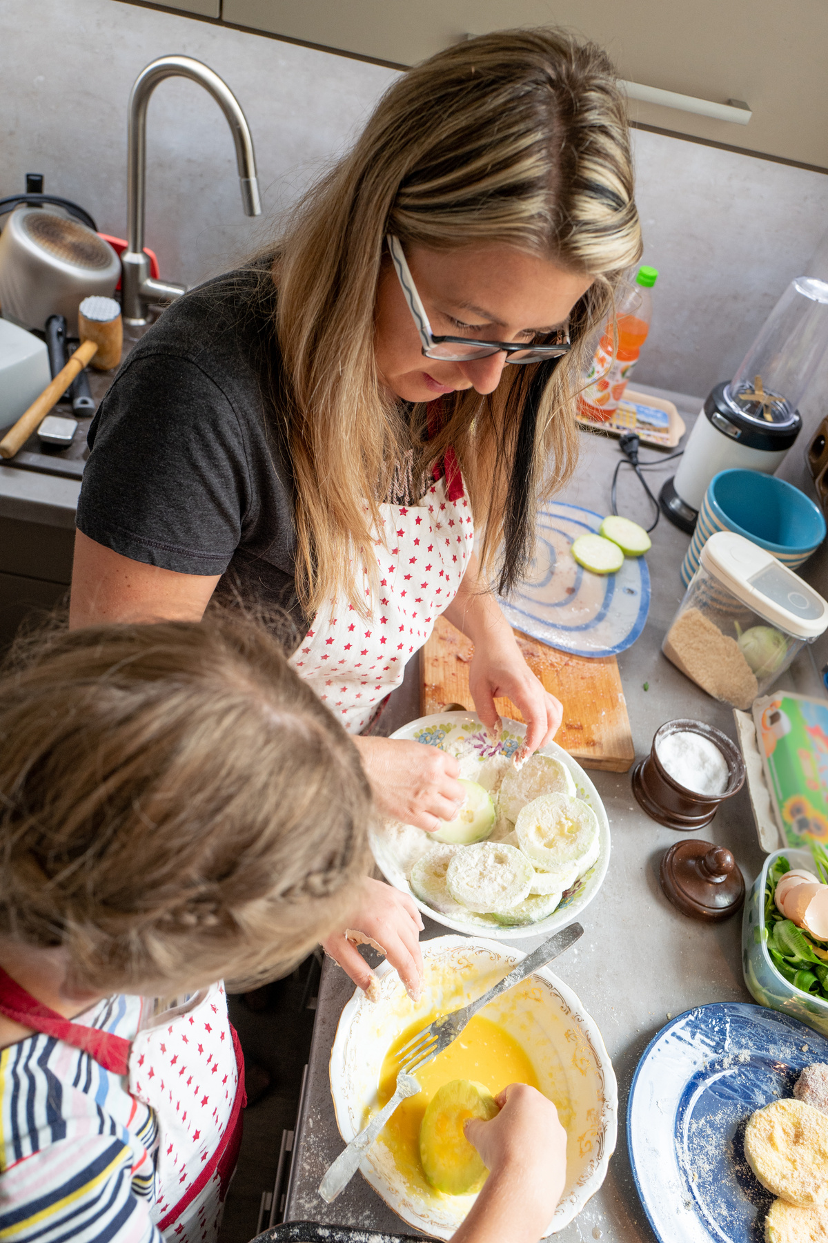 Mum and daughter busy in the kitchen preparing cooking dinner